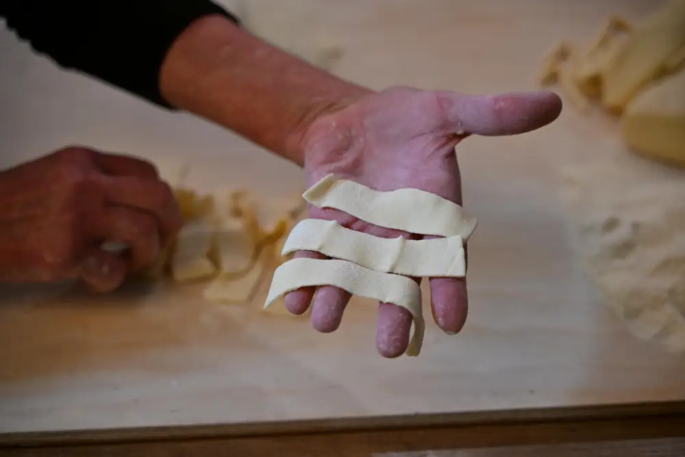 Le lagane appena tagliate, nel palmo della mano della massaia