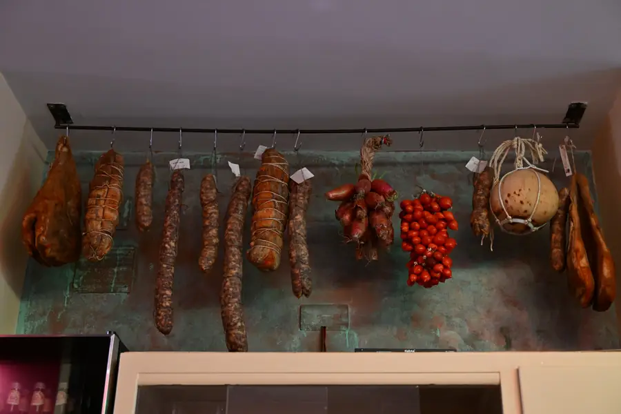 Salumi e pomodori appesi alla parete