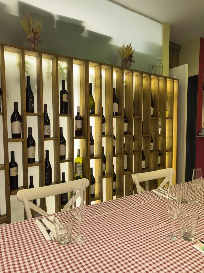 La parete dei vini, con le bottiglie nelle nicchie illuminate
